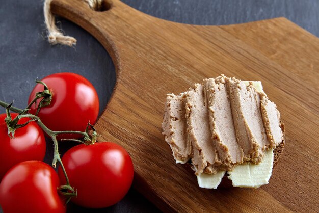 Panino al patè fatto in casa su tavola di legno su tavolo in pietra nera