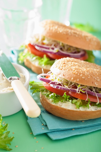 Panino al pomodoro su bagel con crema di formaggio, cipolla e lattuga