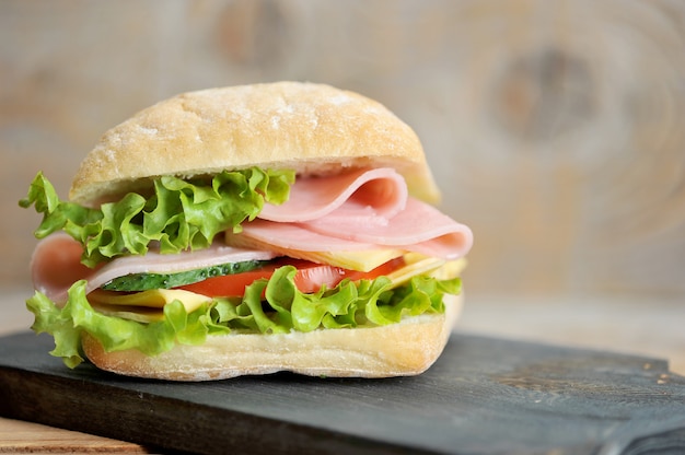 Panino al prosciutto e formaggio su tavola di legno