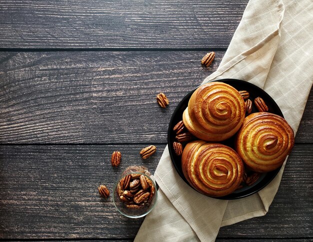 Panino alla cannella e noci pecan caramellate su fondo di legno