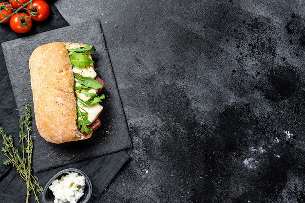 Panino alla ciabatta con formaggio di capra fresco, marmellata di pere e rucola. Vista dall'alto.