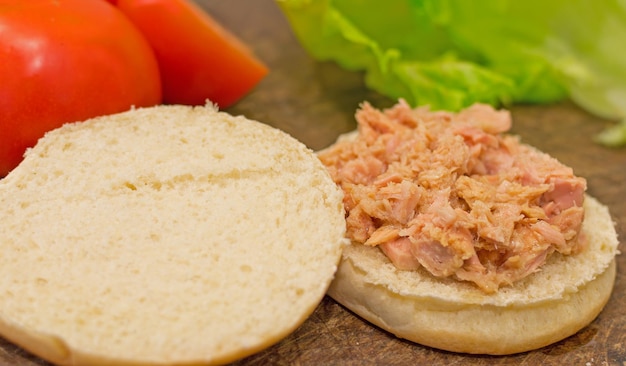 Panino aperto con tonno sopra e ingredienti tutt'intorno