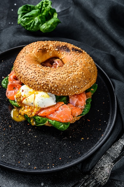 Panino bagel fatto in casa con salmone, crema di formaggio, spinaci e uovo