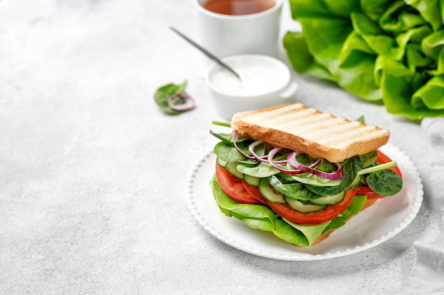 Panino biologico Superfood con verdure su pane grigliato su piatto bianco Spazio di copia