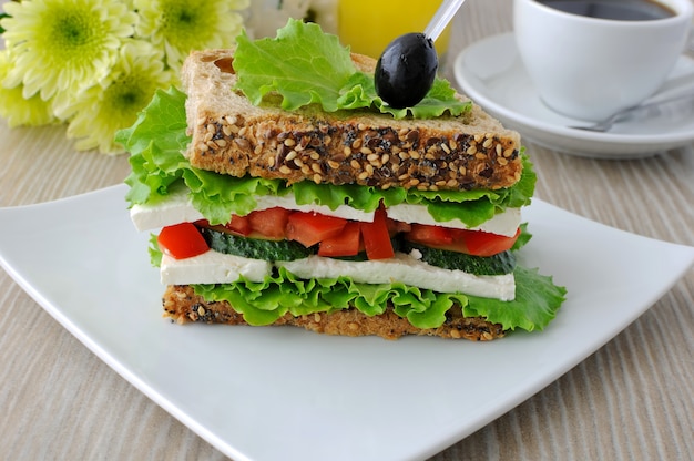 Panino con cereali, formaggio, pomodoro e cetriolo