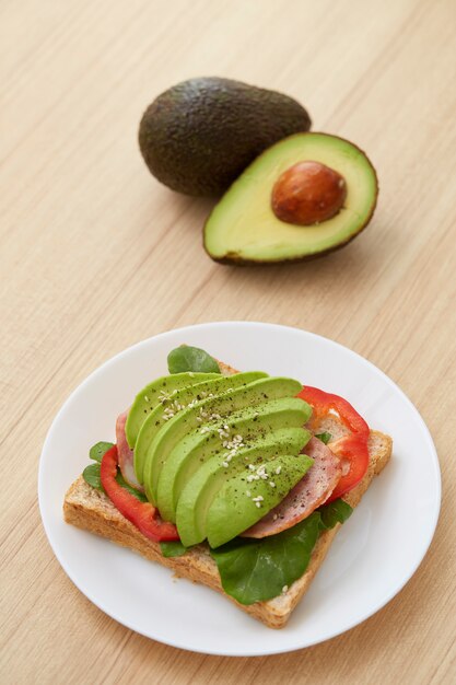 Panino con fette di avocado e pancetta