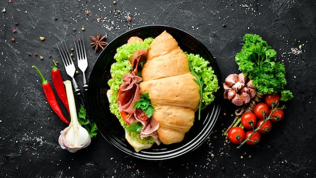 Panino con fette di prosciutto su fondo di legno vecchio Croissant Colazione Vista dall'alto Spazio libero per il testo