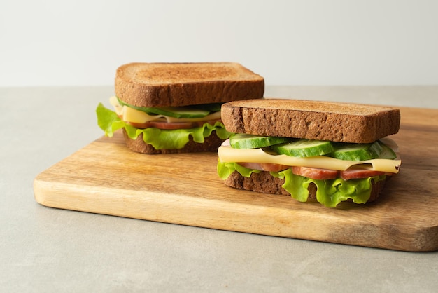 Panino con formaggio di carne e verdure su sfondo grigio