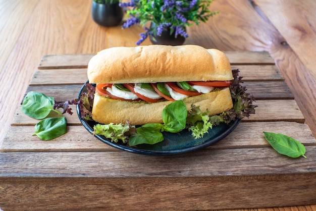 Panino con formaggio, pomodoro, cetriolo e lattuga e verdure a parte