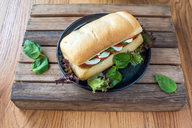 Panino con formaggio, pomodoro, cetriolo e lattuga e verdure a parte