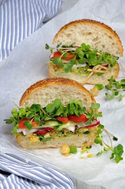 Panino con germogli di ravanello verde ravanello croccante e pomodoro cetriolo con salsa di avocado