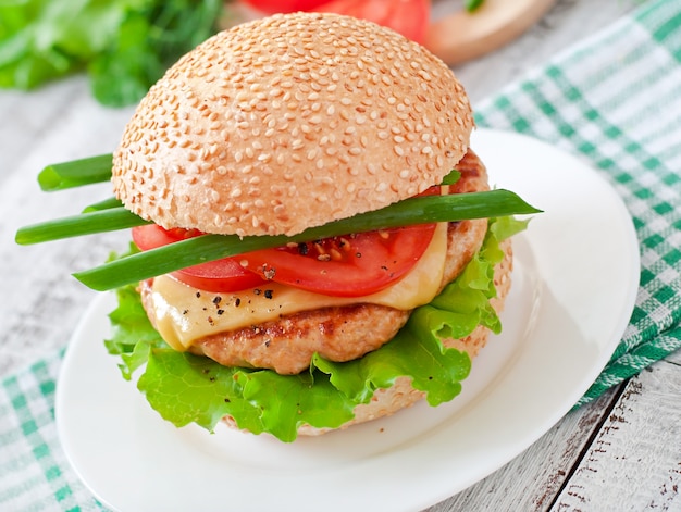 Panino con hamburger di pollo, pomodori, formaggio e lattuga