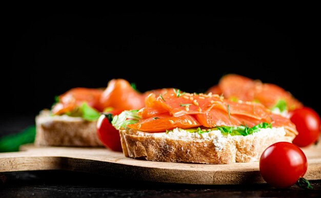 Panino con pezzi di salmone su un tagliere