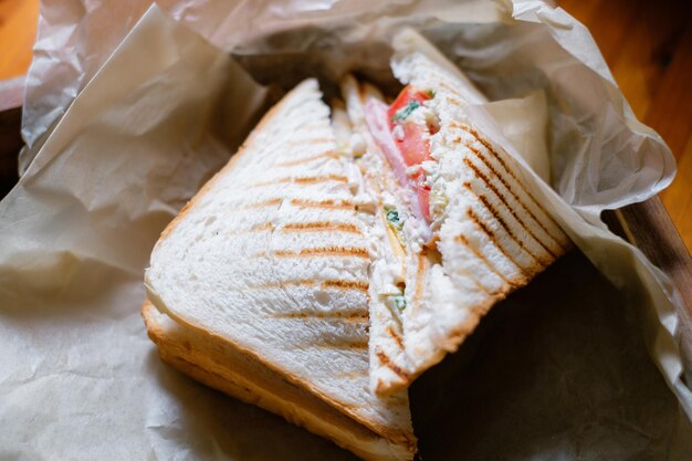 Panino con prosciutto e verdure su carta pergamena Pranzo delizioso