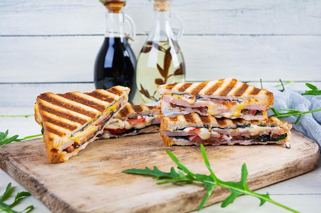 Panino con prosciutto formaggio senape foglie pomodori e cipolla Gustosi panini alla griglia