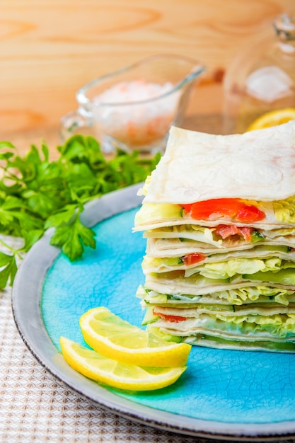 Panino con salmone, ricotta e verdure sul primo piano piatto blu