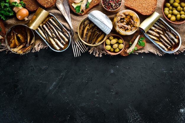 Panino con Spratto Spratto sott'olio su sfondo nero Vista dall'alto Spazio libero per la copia