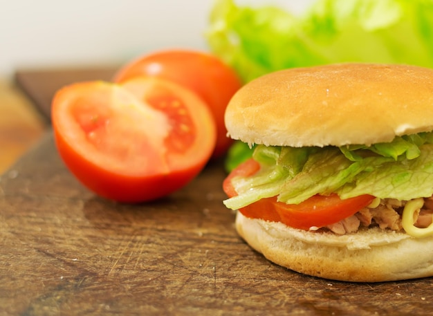 Panino con tonno pomodori e lattuga su un tagliere