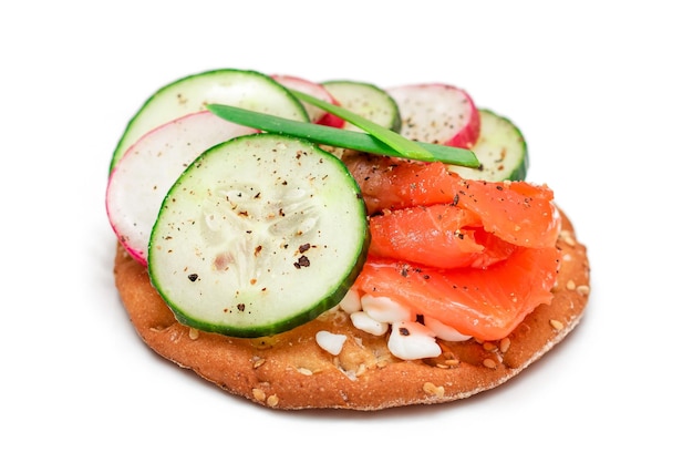 Panino cracker con ricotta di ravanello cetriolo salmone e cipolle verdi isolate