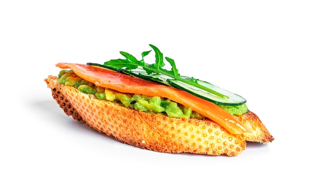 Panino croccante con guacamole, salmone, rucola, cetriolo isolato. Bruschette con avocado. Colazione salutare