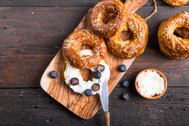 Panino dei bagel con formaggio cremoso e sul mirtillo sulla tavola di legno