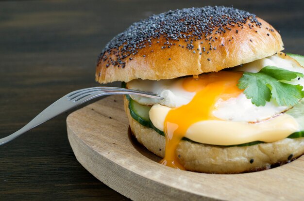 Panino del cetriolo e dell&#39;uovo su fondo di legno.