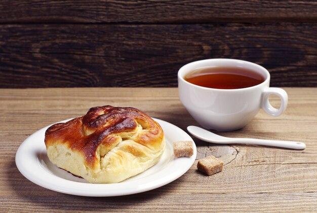 Panino delizioso e tazza di tè sul tavolo di legno