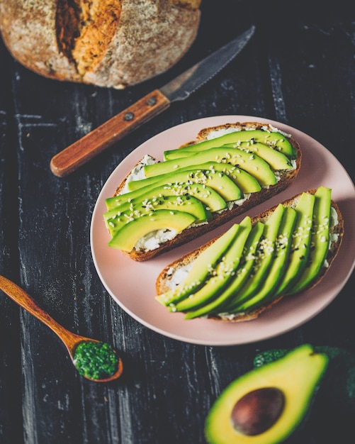 Panino di avocado su pane di segale scuro fatto con avocado affettato fresco