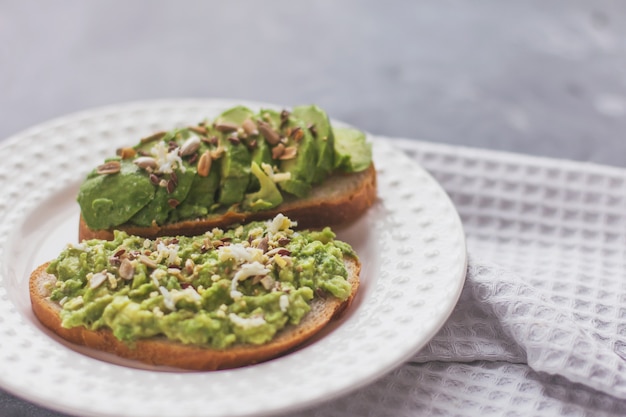 Panino di avocado vegano su un piatto bianco