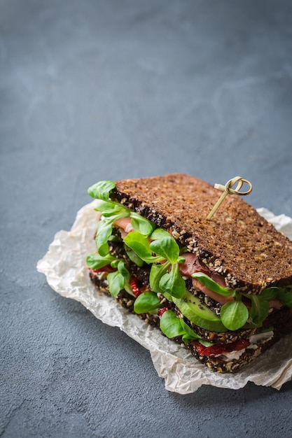 Panino di pane di segale fresco con prosciutto lattuga e pomodoro