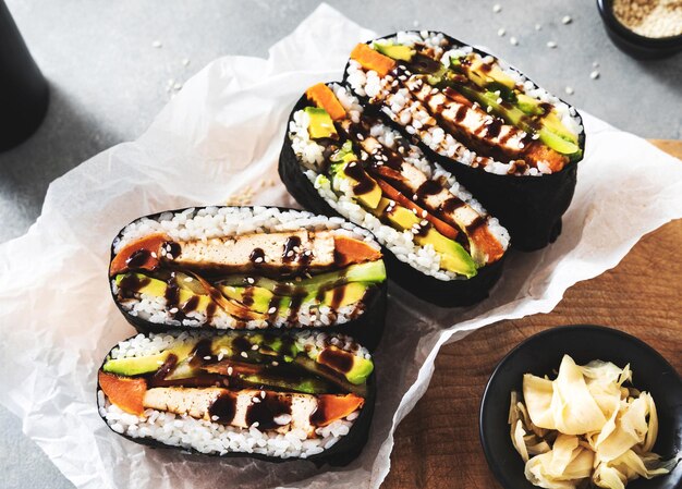 Panino di sushi onigirazu con ripieno di tofu vegano marinato con patate dolci alla salsa di soia e avocado