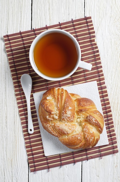 Panino di vimini dolce e tazza da tè sul tavolo