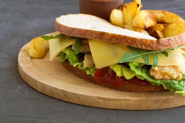 Panino e patate fritte su una tavola di legno.