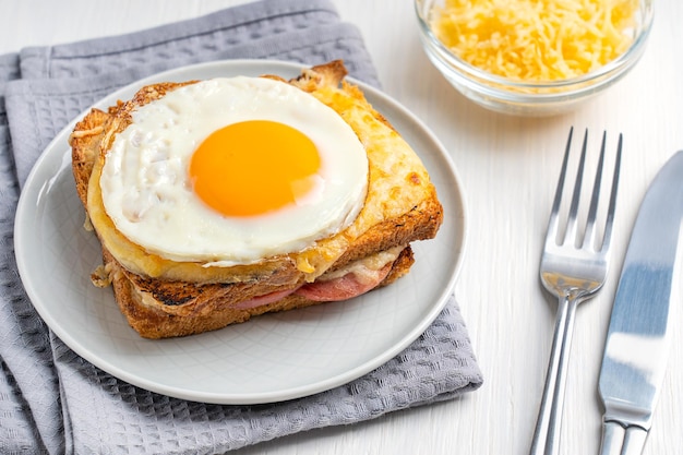 Panino francese caldo Croque Madame fatto in casa con prosciutto e pane tostato condito con uovo fritto