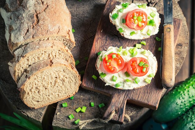 Panino fresco con formaggio fresco, pomodorini ed erba cipollina