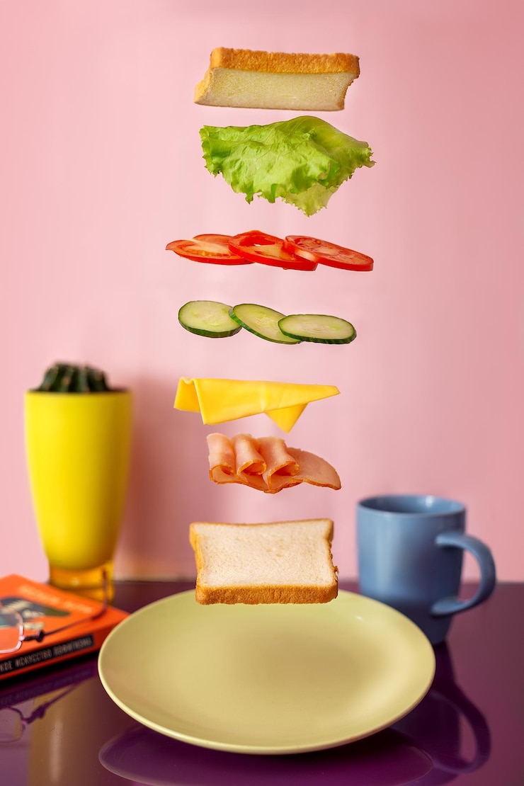 Foto panino fresco con ingredienti volanti isolati su sfondo rosa