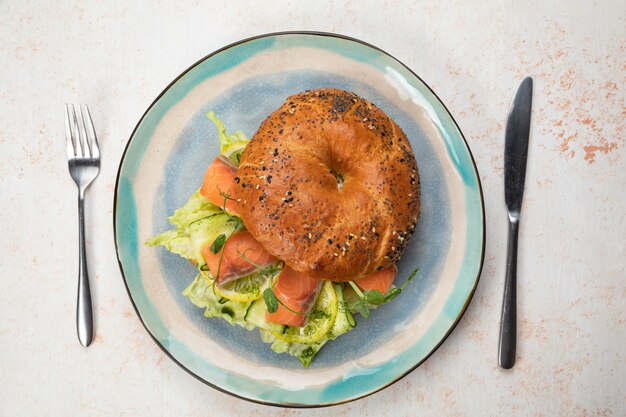 Panino hamburger con salmone, crema di formaggio, insalata.