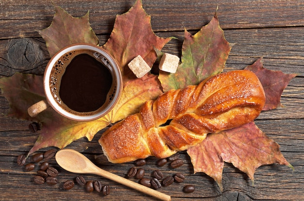 Panino intrecciato dolce e tazza di caffè caldo