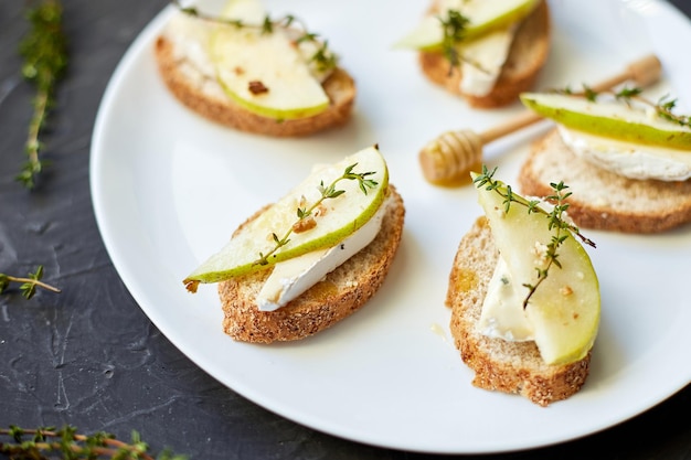 Panino o bruschetta con pera e gorgonzola su piatto bianco