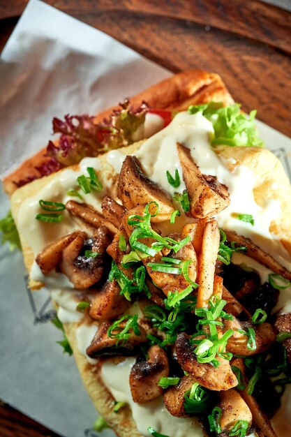 Panino per la colazione con frittata e funghi e salsa bianca Sfondo in cemento Luce dura Cibo vegetariano Vista dall'alto