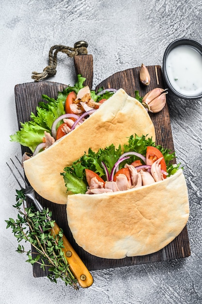 Panino Pita con pollo arrosto, verdure e salsa deliziosa. Sfondo bianco. Vista dall'alto.