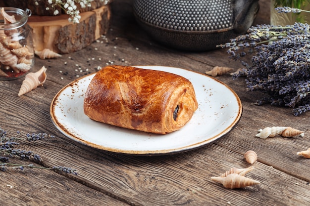 Panino ripieno al cioccolato dolce al forno sulla superficie in legno