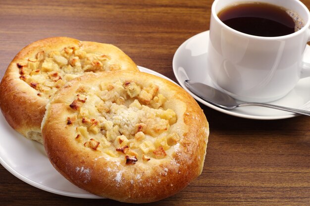 Panino rotondo con mela e tazza di caffè sul tavolo