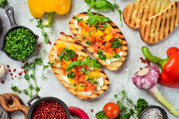 Panino vegano con peperoni dolci formaggio verdure e basilico Bruschetta Vista dall'alto su fondo di pietra