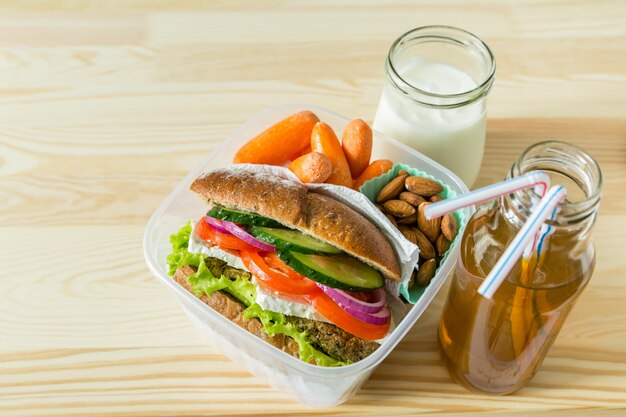 Panino vegano in scatola di pranzo con carote e noci