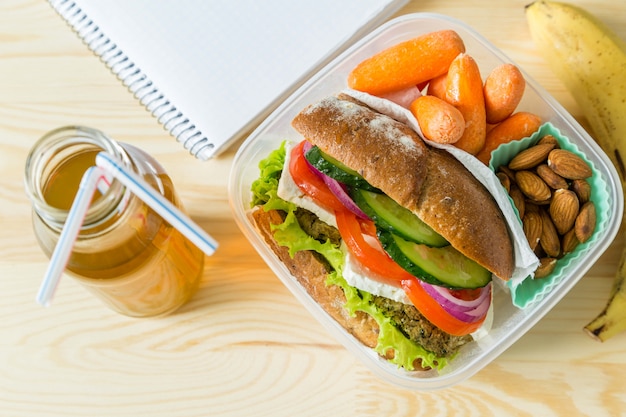 Panino vegano in scatola di pranzo con carote e noci