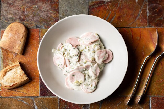 Panna acida e verdure salsiccia insalata sul piatto con pane Insalata semplice sul piatto