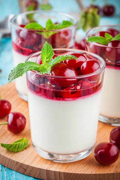 Panna cotta dolce fatta in casa con salsa di ciliegie e menta