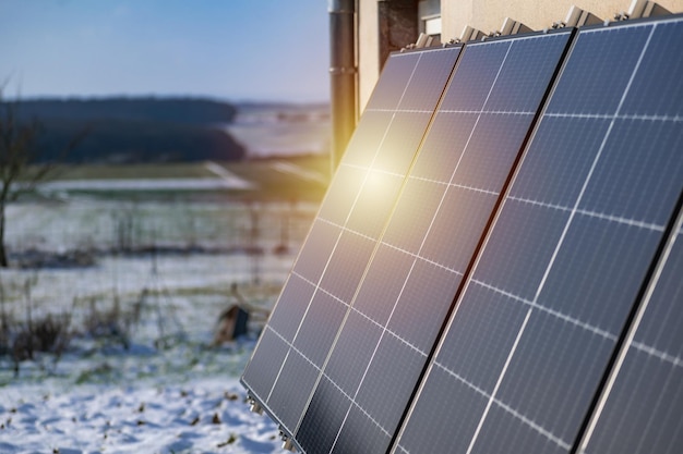 Pannelli solari con neve a terra su una parete ben esposta di una casa individuale che fa risparmi dopo la crisi energetica gesto ecocitizen energia verde