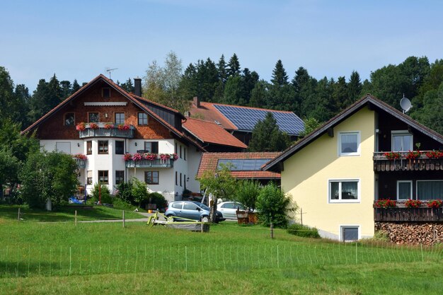 Pannelli solari sui tetti dei cottage vicino alla foresta Energia alternativa e protezione ambientale